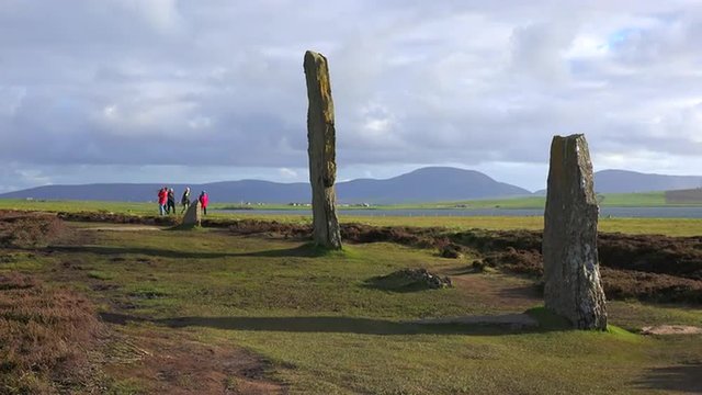 People walk near the sacred Celtic stones on the Islands of Orkney in Northern Scotland.