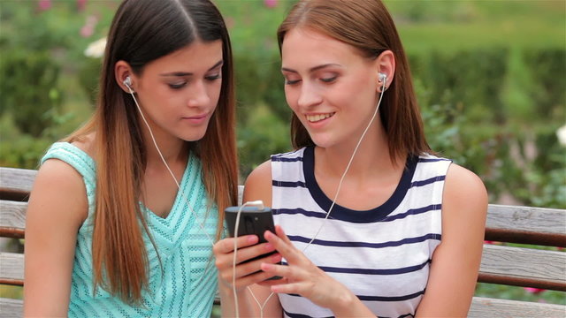Two attractive girls listening to music