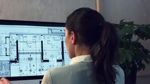 Woman working at home office architectural plans