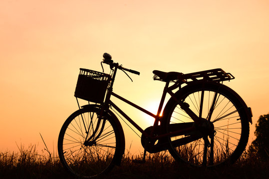 beautiful landscape image with Bicycle silhouette  at sunset