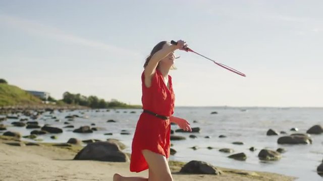 Young Girl is Playing in Badminton on the Beach