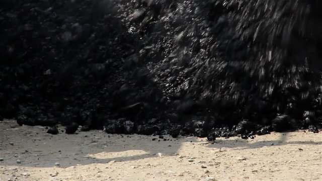 Hot asphalt poured by the machine on the road. roadworks. Asphalt, close up. 