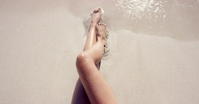 Top view of woman holding pineapple cocktail sexy legs on beach self shot
