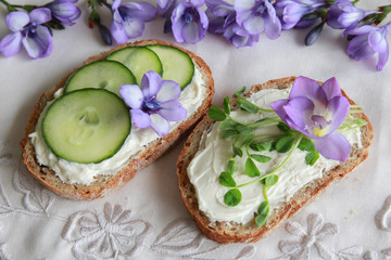 Green sourdough open face sandwiches with purple edible flowers