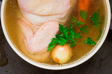 Chicken with onions, carrots, parsley in a broth