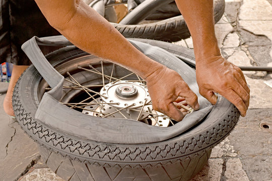 Motorcycle mechanic changing a wheel.