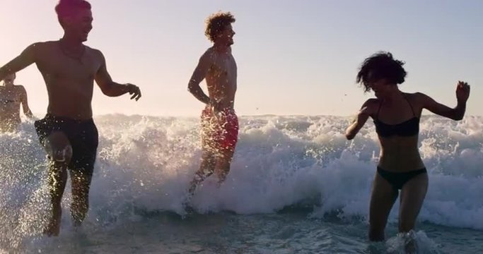 Diverse Group of friends swimming in the sea at sunset