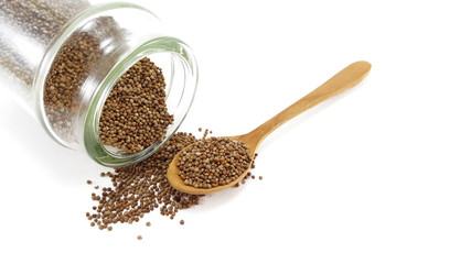Perilla seed in glass jar with wooden spoon on white background