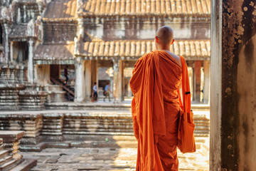 Naklejka premium Buddhist monk looking at courtyard of Angkor Wat, Cambodia