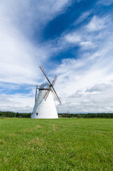 Scenic windmill on meadow, summertime rural landscape