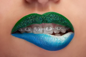 Schließen Sie die blauen und grünen Lippen des Mundes mit glitzernden Klammern © DC Studio