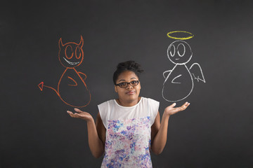 African woman with an I don't know angel and devil gesture on blackboard background