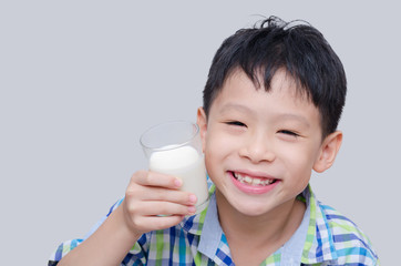 Asian boy smiles and holding a glass of milk