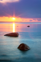 Panele Szklane Podświetlane  zachód słońca nad morzem z piękną wodą i chmurami