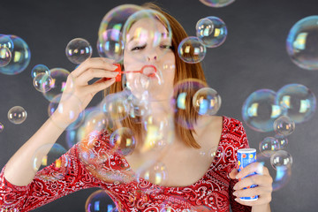 Frau pustet viele Seifenblasen