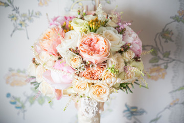 
Elegant bridal bouquet of roses in light colors and pearl beads decor.