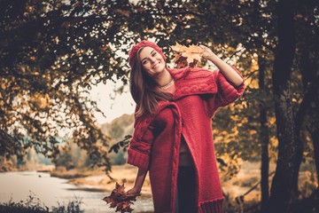 Beautiful woman wearing knitted coat in autumn park