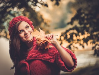 Beautiful woman wearing knitted coat in autumn park