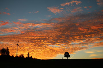 Fototapeta na wymiar Sonnenaufgang mit Wolkenhimmel und Windrad