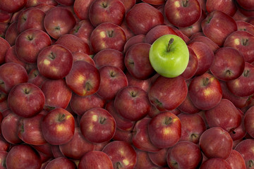 green apple on the top of red apples