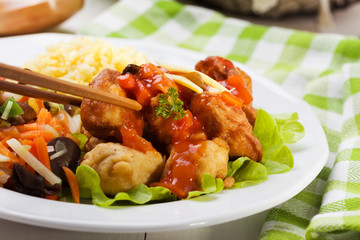 Fried chicken pieces in batter with sweet and sour sauce