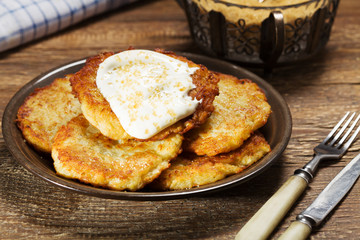 Homemade potato pancakes served with sour cream and brown sugar