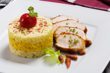Portion of risotto with roasted chicken.