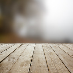 Naklejka na ściany i meble Wooden perspective floor with planks on blurred natural autumn background, can use for display or montage your products. template. Copy space