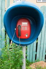 Red payphone in blue booth