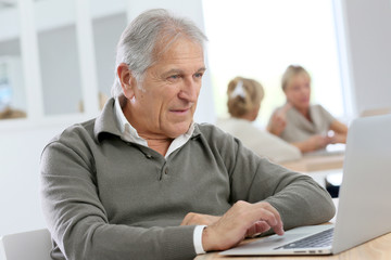 Fototapeta na wymiar Senior man using laptop computer