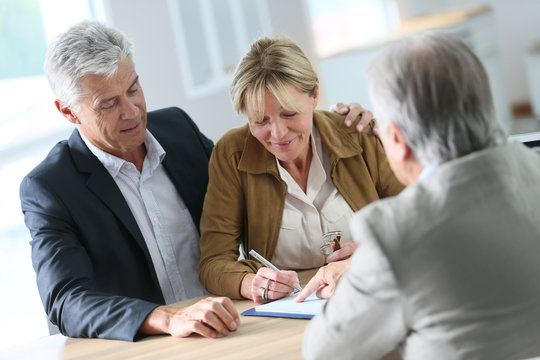 Senior couple meeting real-estate agent for investment