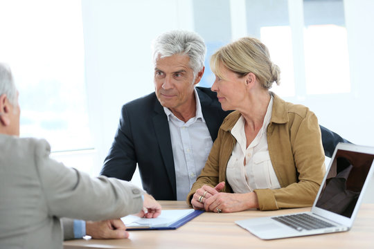 Senior couple meeting real-estate agent for investment