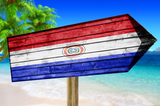 Paraguay Flag wooden sign on beach background