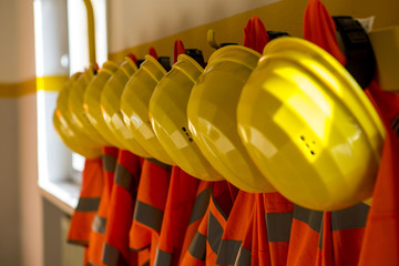 Fila di caschi da lavoro protettivi con giubbetti alta visibilità