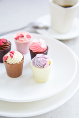 Small cup with heart shape chocolate on white plates