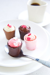 Small cup with heart shape chocolate on white plates