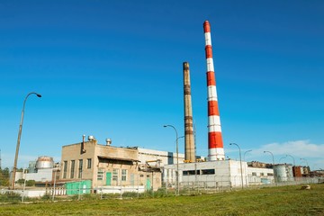 Fototapeta na wymiar Pipes of thermal power plant against blue sky, established in Volgodonsk.