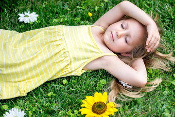 Girl with closed eyes lies on a grass