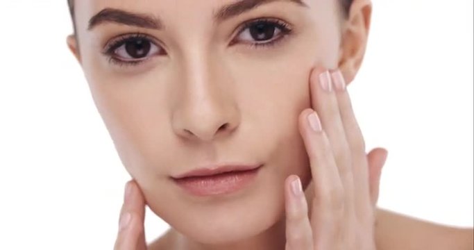 Beauty portrait of woman touching beautiful face in slow motion skincare concept on a white background 