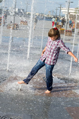 girl playing in the fountain