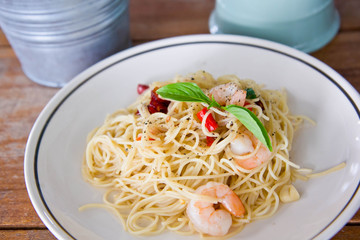 Chilli prawn spaghetti on wooden table in restaurant