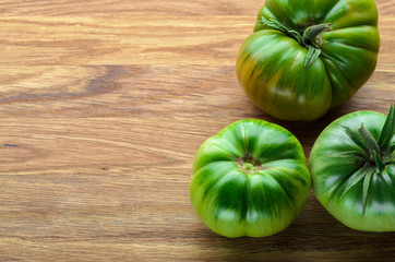 Unripe tomatoes on a wooden board, copyspace. Agriculture, Gardening, Harvest Concept.