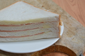 bologna sandwich on wooden chop plate