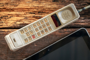 vintage mobile phone with tablet on old table (vintage style)