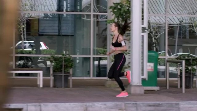 Athletic running fitness woman in urban city