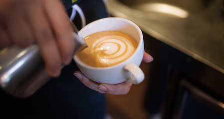 Barista makes latte art, focus in milk and coffee, vintage color