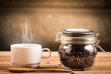 Obraz na płótnie Canvas Coffee cup and saucer on a wooden table. Dark background.