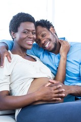 Fototapeta premium Portrait of pregnant woman with husband relaxing at home