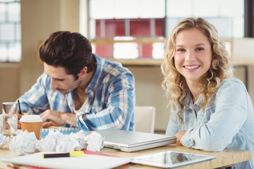 Portrait of woman with colleague working 