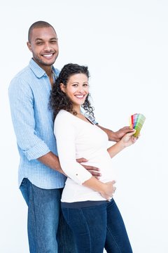 Portrait of smiling husband with wife holding colour samples